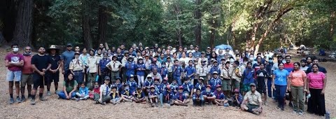 Pack 415 scouts and families gathered outdoors in the woods
